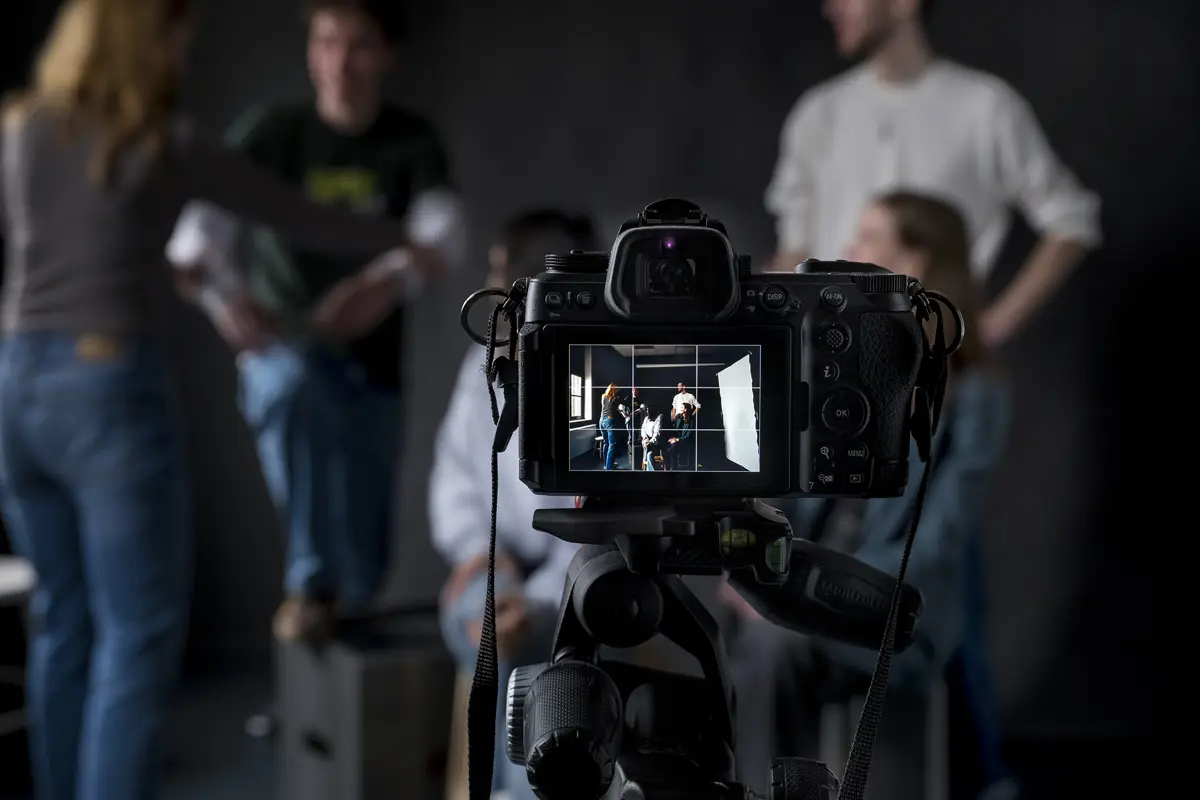 Studenten werken aan een opname met camera in een opleiding