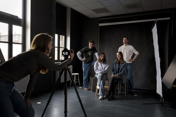 Studenten maken een fotoshoot in een studio tijdens een opleiding fotografie